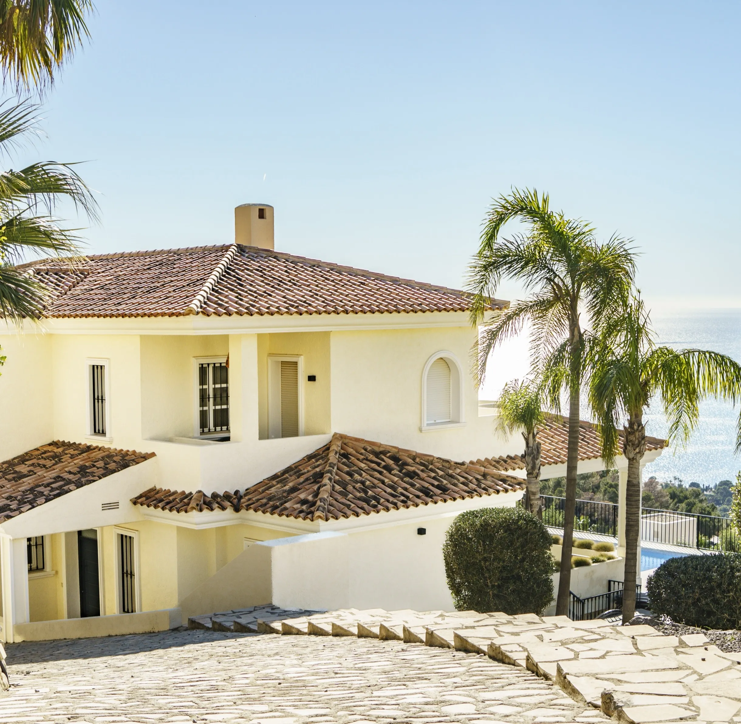 Klassieke mediterrane villa met terracotta daken en palmen aan de Costa Blanca, met uitzicht op de Middellandse Zee