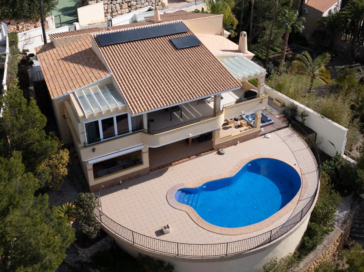 Glas-glas zonnepanelen op het pannendak van een villa met zwembad in Calpe