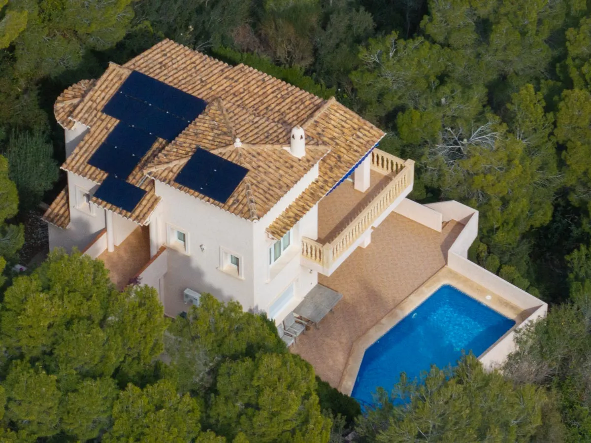 Glas-glas zonnepanelen op het pannendak van een vrijstaande villa in de bossen rond Gandía