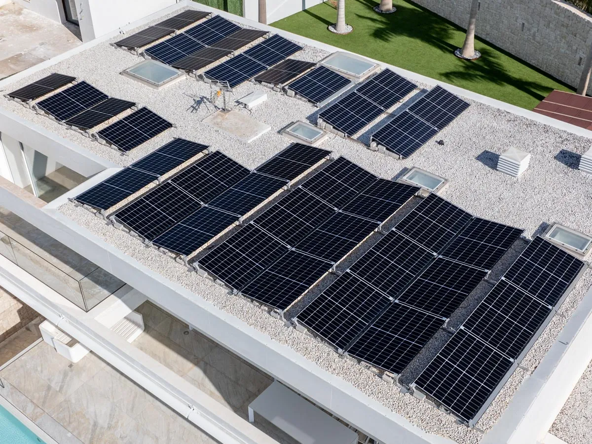 Glas-glas zonnepanelen op stelframes op het platte dak van een moderne villa rond de Montgó in Jávea