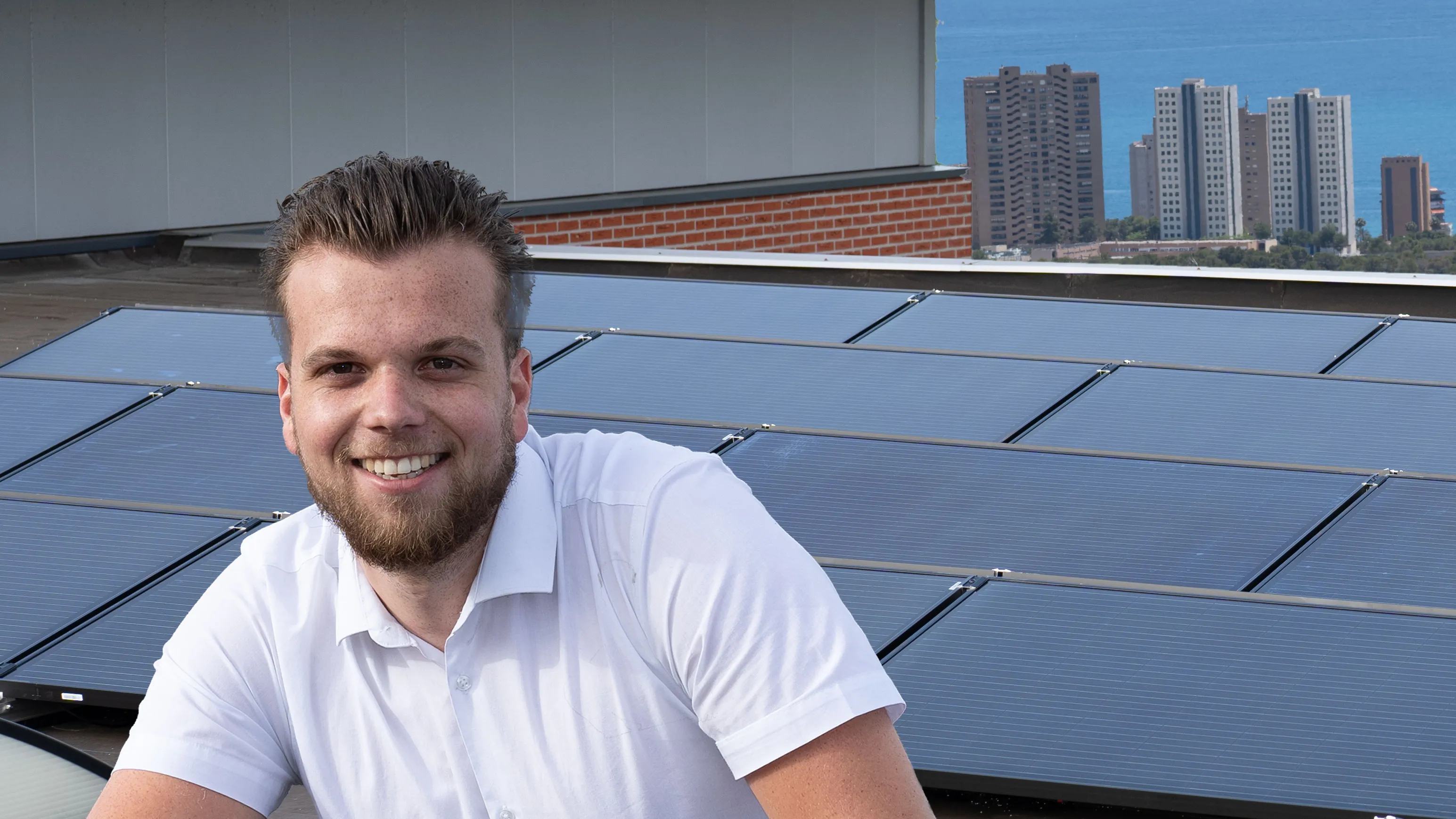 Lachende Solarfit-adviseur voor zonnepanelen op een dak in Benidorm