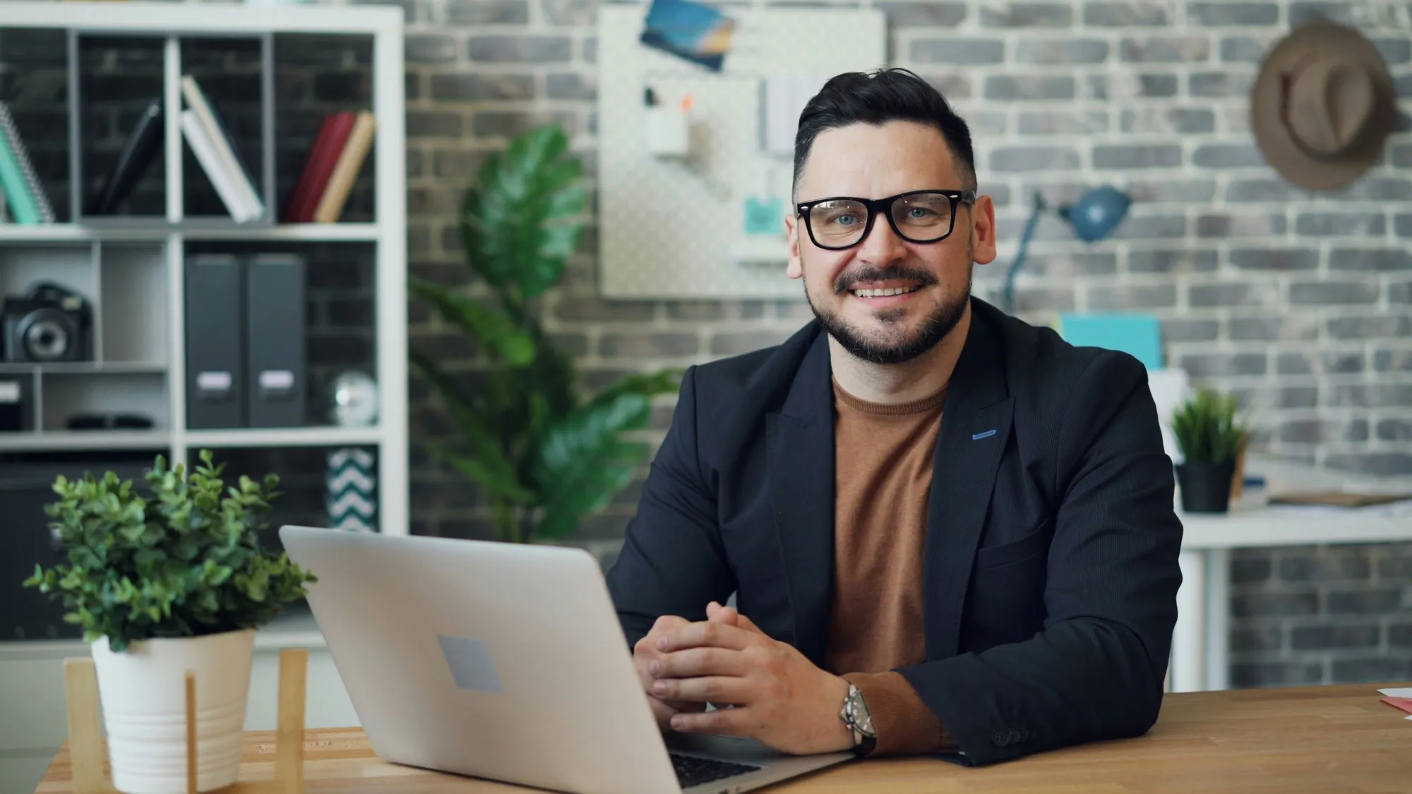Lachende specialist achter een bureau met laptop in een modern kantoor